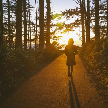 female walking on a path into the sunset at cape disappointment