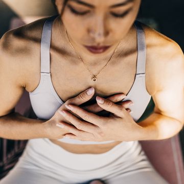 high angle view of woman exercising with hands on chest