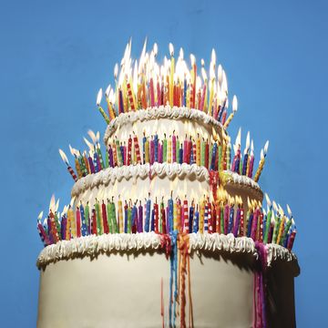 3 tiered birthday cake with burning candles