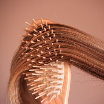 young woman with comb brushing her blonde hair